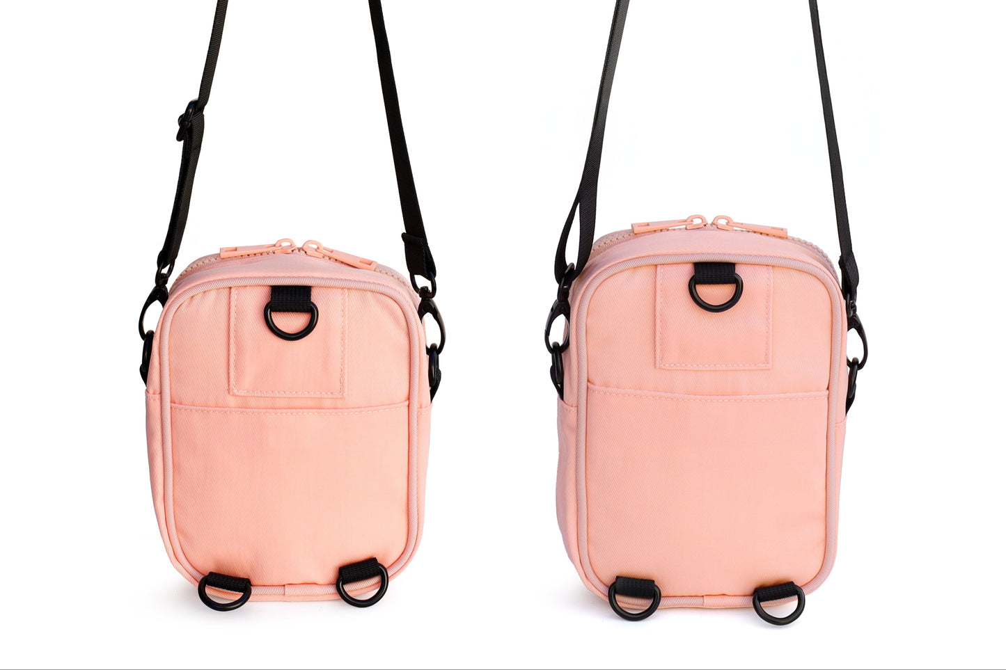 Two pink crossbody bags with black straps on a white background