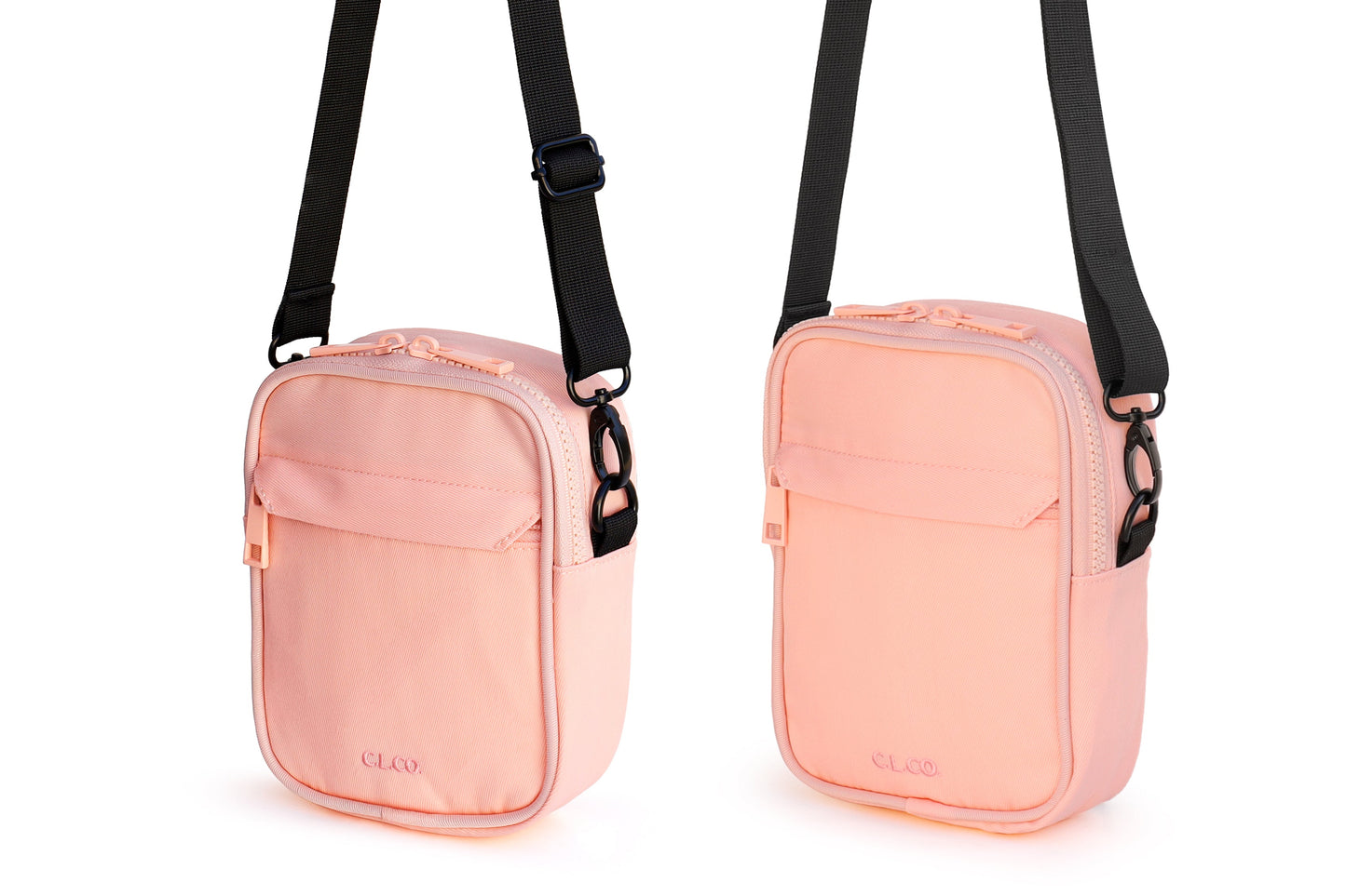 Pink crossbody bag with black straps on a white background